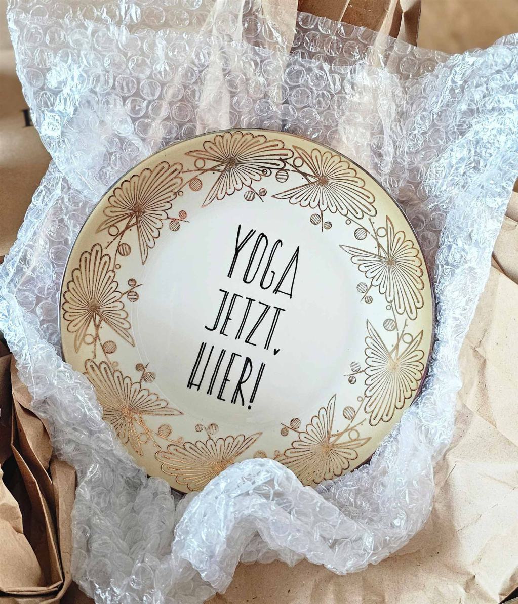 alter Telelr handschriftlich bemalt mit einem Yoga-Text
